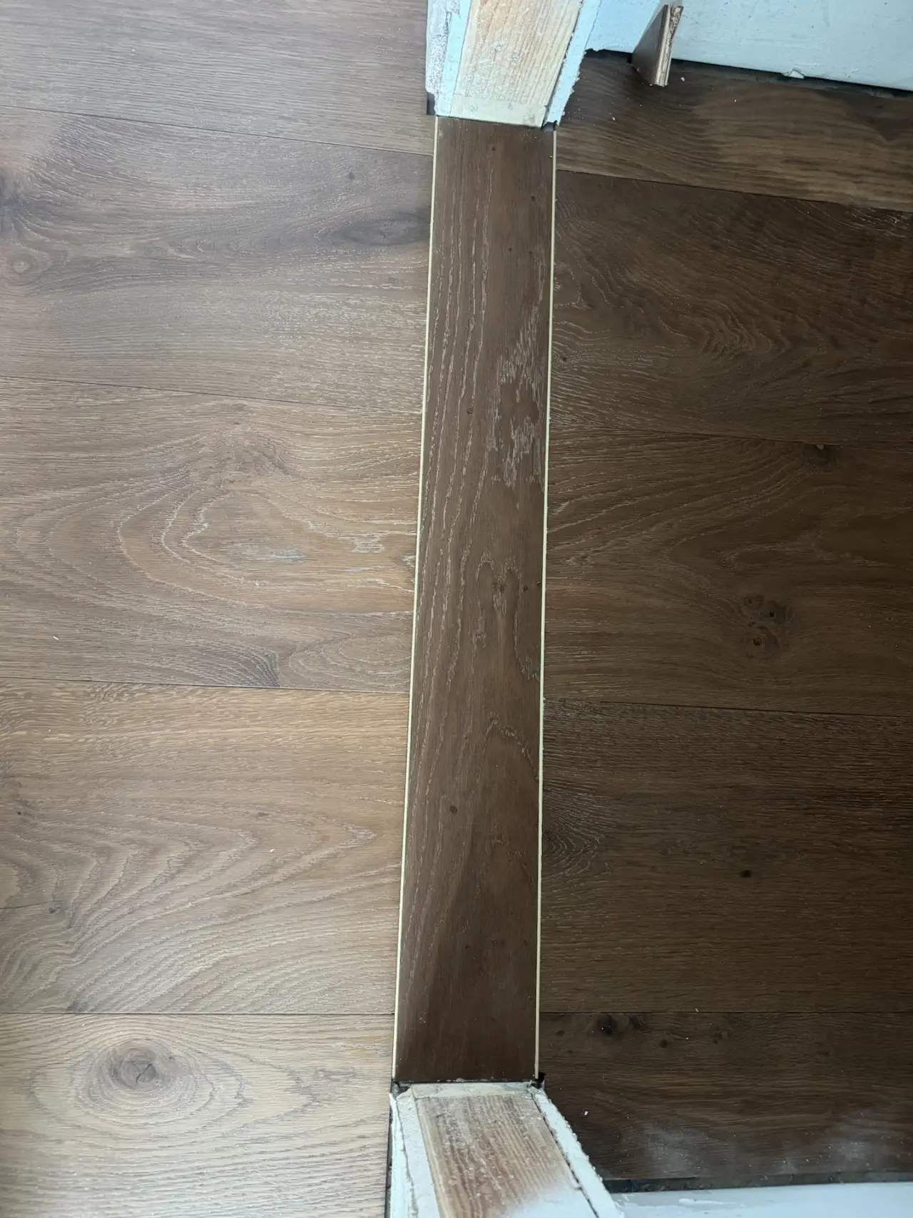 Details · A custom wood transition at every doorway.