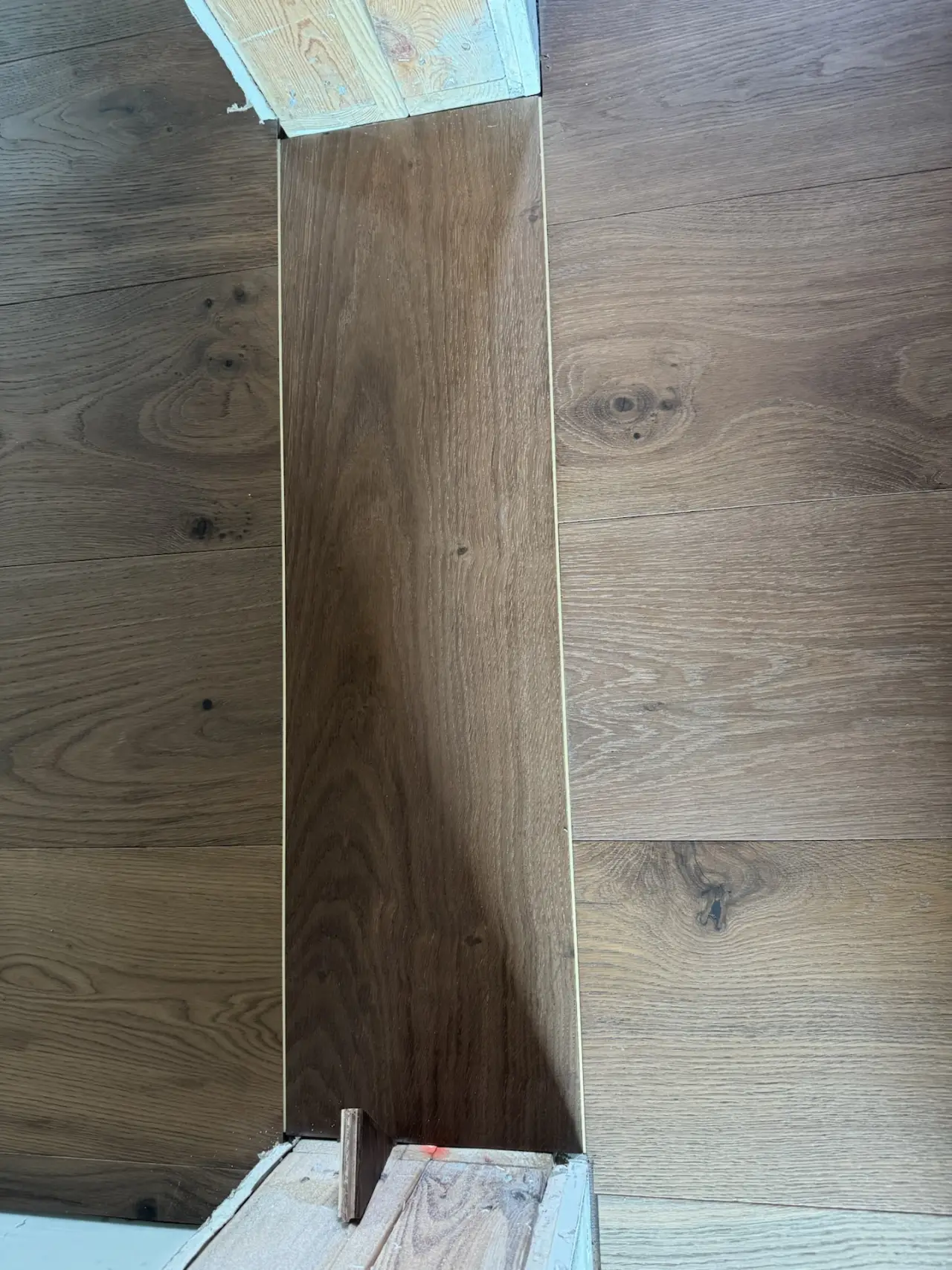 Details · A custom wood transition at every doorway.